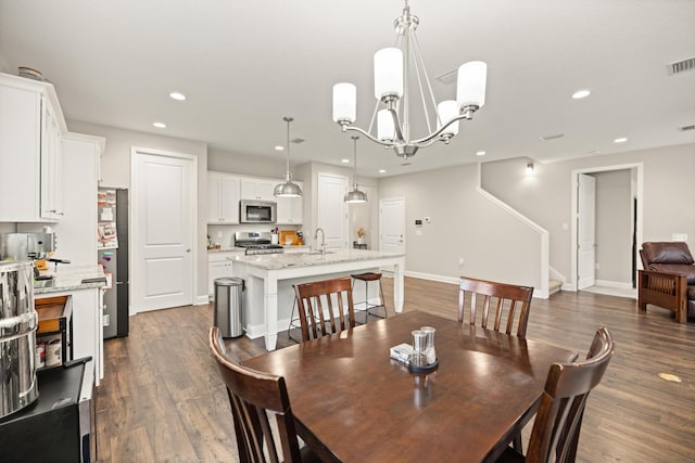 dining area featuring dark wood-type flooring, recessed lighting, and a chandelier