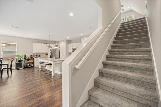 stairway with recessed lighting and wood finished floors