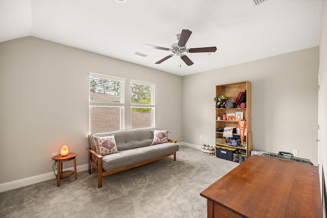 sitting room with visible vents, baseboards, ceiling fan, vaulted ceiling, and light colored carpet