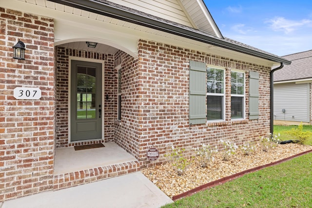 view of exterior entry featuring brick siding