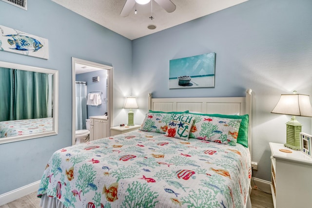 bedroom with light wood-style floors, ensuite bathroom, baseboards, and visible vents