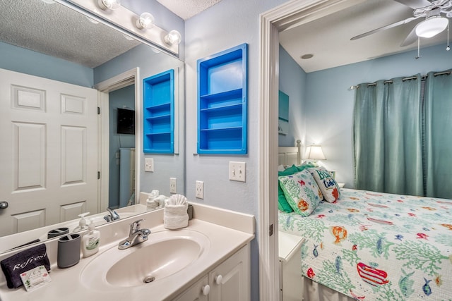 bathroom with a textured ceiling, vanity, and a ceiling fan