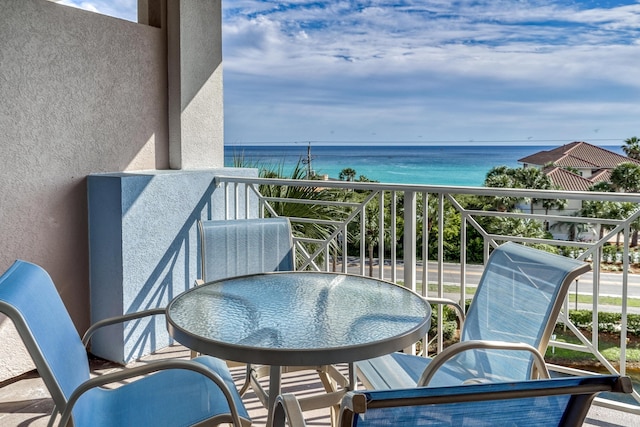 balcony with a water view and outdoor dining space