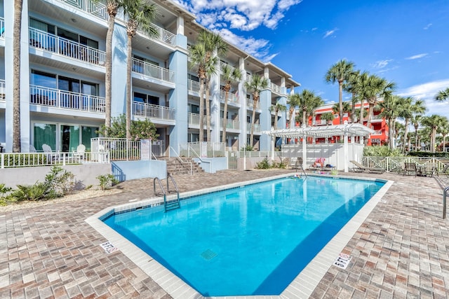 pool with a patio, a pergola, and fence