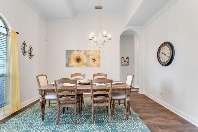 dining room with baseboards, an inviting chandelier, dark wood-style floors, crown molding, and arched walkways