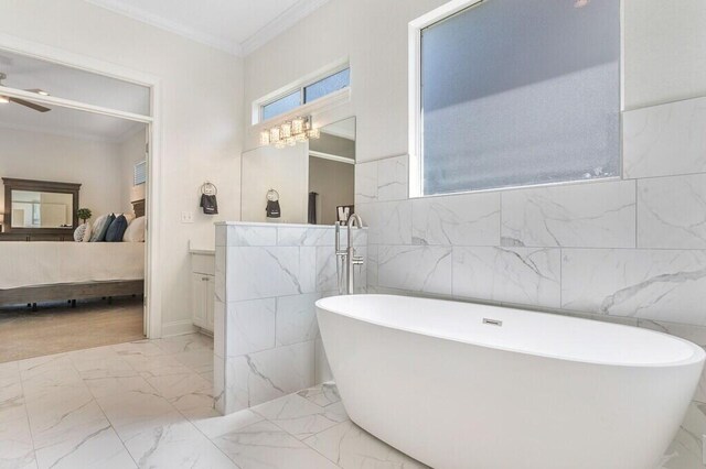 ensuite bathroom with ensuite bathroom, a freestanding bath, ornamental molding, a ceiling fan, and marble finish floor