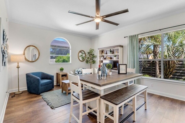 dining area featuring ornamental molding, baseboards, a ceiling fan, and wood finished floors