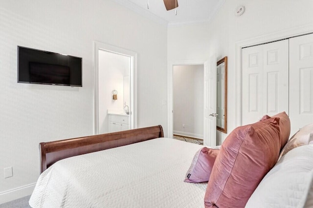 bedroom featuring baseboards, a closet, ensuite bath, crown molding, and ceiling fan