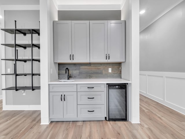 1160 Deer Moss Loop, Niceville, FL 32578 - bar featuring tasteful backsplash, indoor wet bar, a sink, light wood-style floors, and wine cooler