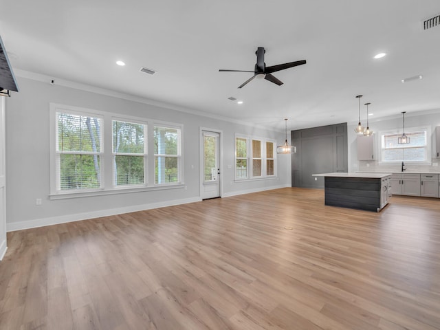 1160 Deer Moss Loop, Niceville, FL 32578 - unfurnished living room with light wood-type flooring, recessed lighting, crown molding, visible vents, and ceiling fan with notable chandelier