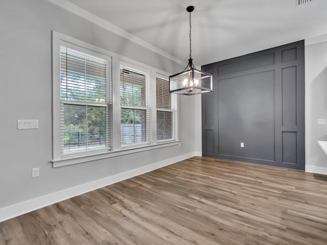 1160 Deer Moss Loop, Niceville, FL 32578 - unfurnished dining area featuring visible vents, baseboards, a chandelier, and wood finished floors