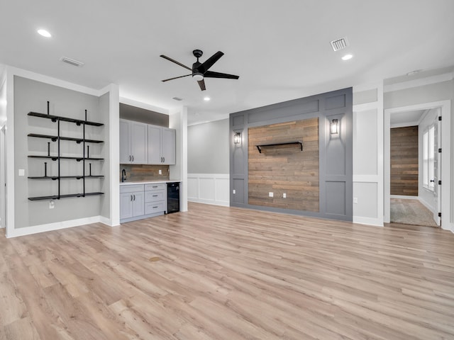1160 Deer Moss Loop, Niceville, FL 32578 - unfurnished living room featuring visible vents, ornamental molding, ceiling fan, wet bar, and beverage cooler