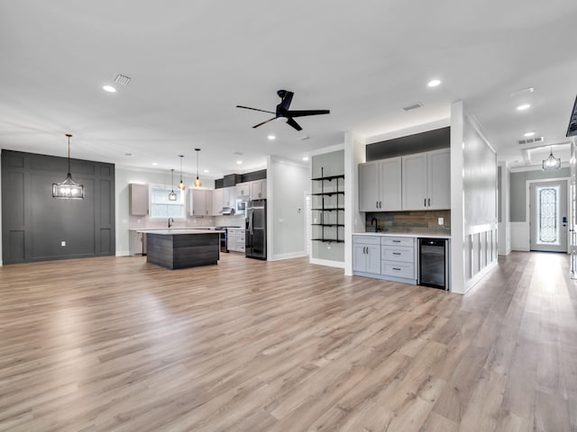 1160 Deer Moss Loop, Niceville, FL 32578 - unfurnished living room with crown molding, light wood-type flooring, visible vents, recessed lighting, and beverage cooler