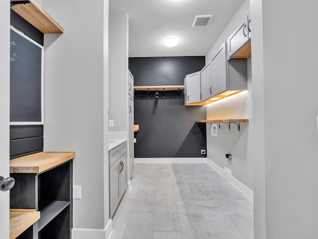 1160 Deer Moss Loop, Niceville, FL 32578 - clothes washing area with visible vents, marble finish floor, and baseboards