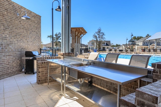 1160 Deer Moss Loop, Niceville, FL 32578 - view of patio featuring outdoor dry bar, a residential view, a community pool, and area for grilling