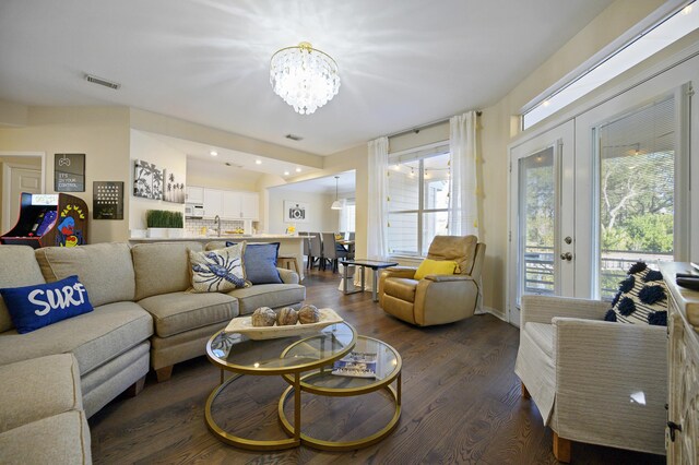 8855 Baypine Dr, Miramar Beach, FL 32550 - living area with dark wood finished floors, visible vents, french doors, and an inviting chandelier