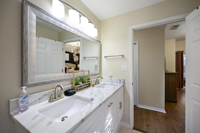 8855 Baypine Dr, Miramar Beach, FL 32550 - bathroom featuring wood finished floors, a sink, visible vents, and double vanity