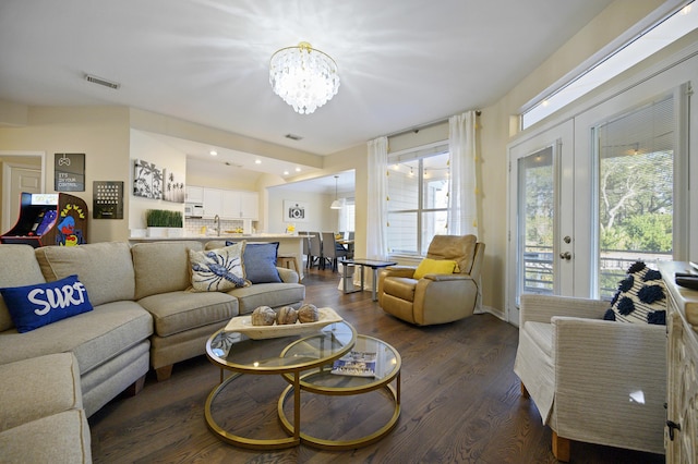 8855 Baypine Dr, Miramar Beach, FL 32550 - living area with dark wood finished floors, visible vents, french doors, and an inviting chandelier