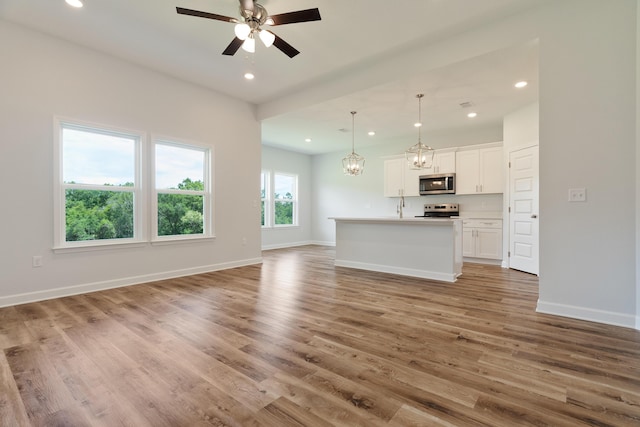 6117 Tansey St, Crestview, FL 32539 - unfurnished living room featuring light wood-type flooring, recessed lighting, a ceiling fan, a chandelier, and baseboards