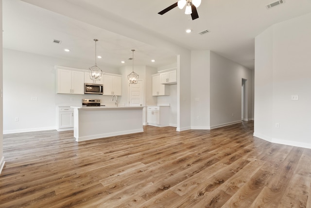 6117 Tansey St, Crestview, FL 32539 - unfurnished living room featuring ceiling fan, light wood-type flooring, a chandelier, baseboards, and recessed lighting