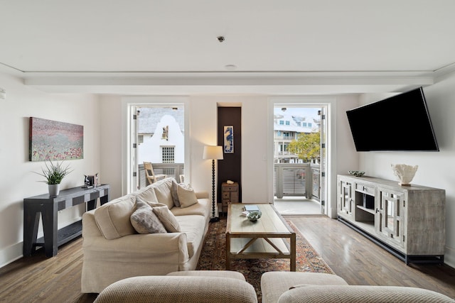 living room with a wealth of natural light, baseboards, and wood finished floors