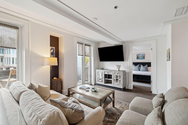 living area featuring visible vents and wood finished floors