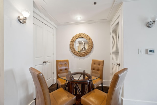 dining area with ornamental molding, baseboards, and wood finished floors