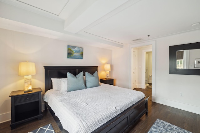 bedroom featuring dark wood-style flooring, baseboards, visible vents, and ensuite bathroom