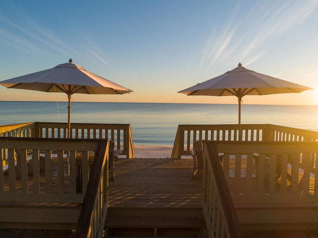 dock area featuring a deck with water view and a beach view