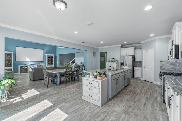 730 Cornelia St, Freeport, FL 32439 - kitchen featuring appliances with stainless steel finishes, a sink, crown molding, recessed lighting, and a kitchen island with sink