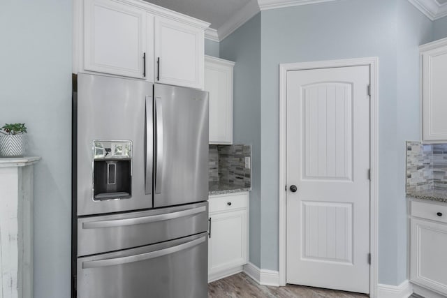 730 Cornelia St, Freeport, FL 32439 - kitchen featuring stainless steel fridge, backsplash, crown molding, and white cabinets