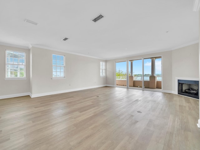 unfurnished living room featuring visible vents, light wood-type flooring, and a healthy amount of sunlight