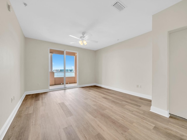 unfurnished room with visible vents, ceiling fan, light wood-style floors, and baseboards