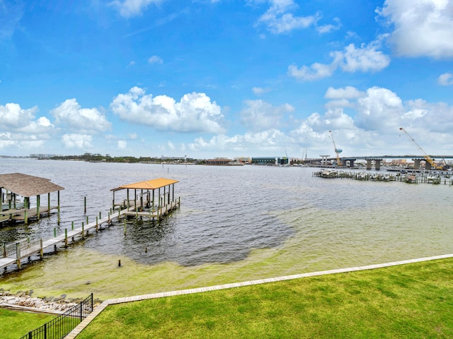 dock area featuring a water view, a yard, and boat lift