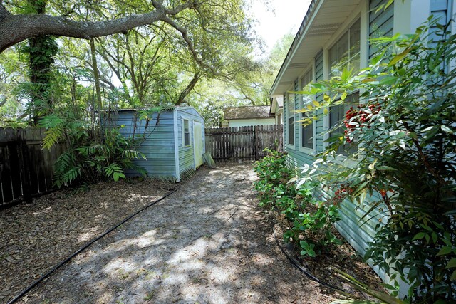 exterior space with an outbuilding, a fenced backyard, and a storage shed