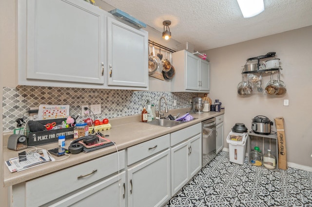 5362 Woodland St, Crestview, FL 32539 - kitchen featuring a sink, tasteful backsplash, stainless steel dishwasher, light countertops, and a textured ceiling