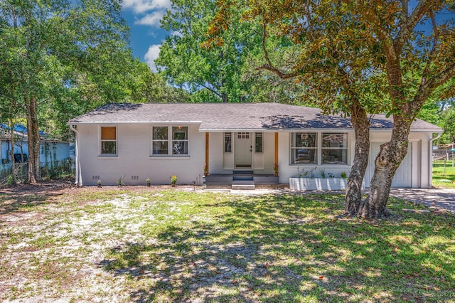 ranch-style home with a shingled roof, fence, a front lawn, and brick siding