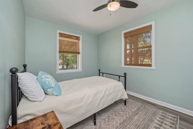 bedroom featuring baseboards, ceiling fan, and wood finished floors