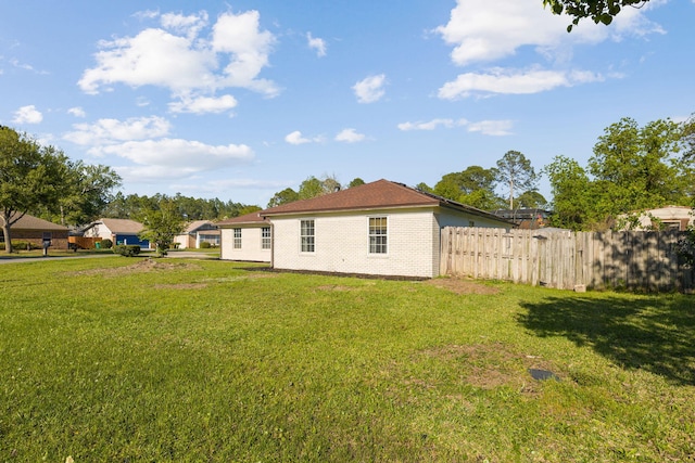 back of house with fence and a lawn