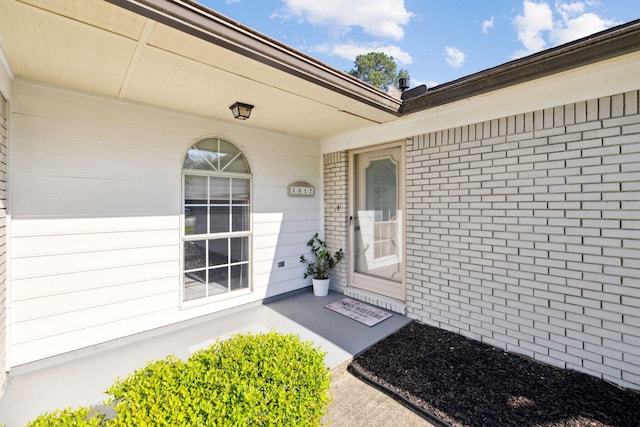 property entrance featuring brick siding