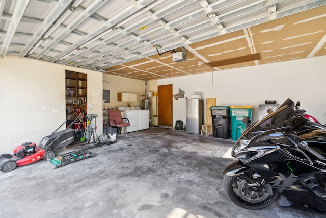 garage with washer and dryer, a garage door opener, and freestanding refrigerator