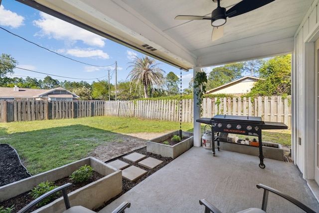 view of patio with a fenced backyard, a garden, and a ceiling fan