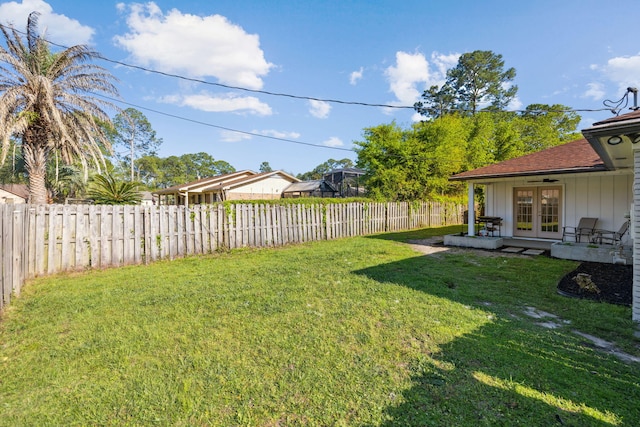 view of yard featuring french doors and a fenced backyard