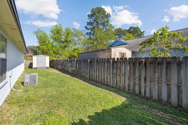 view of yard with an outbuilding, a shed, and a fenced backyard