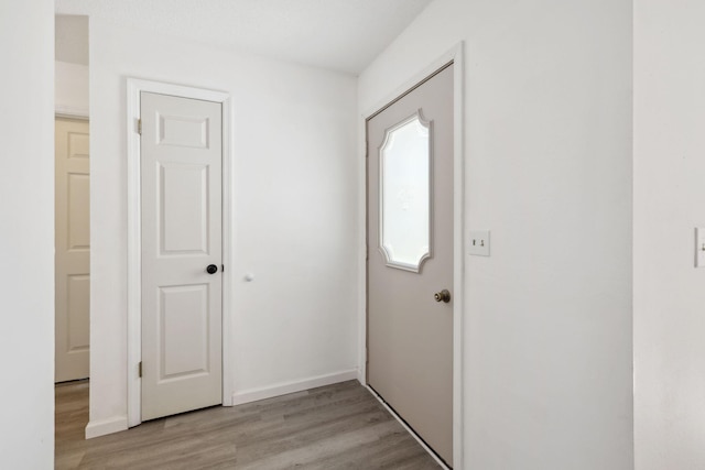 entryway with light wood finished floors and baseboards