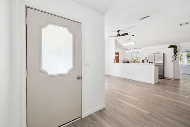 foyer with light wood-style floors, plenty of natural light, visible vents, and a ceiling fan