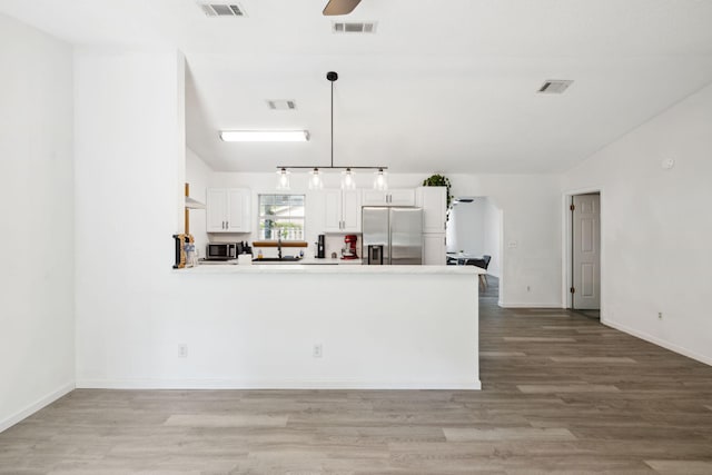 kitchen featuring visible vents, light wood-type flooring, a peninsula, white cabinetry, and stainless steel appliances