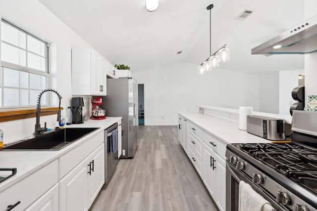 kitchen featuring white cabinetry, vaulted ceiling, visible vents, appliances with stainless steel finishes, and a sink