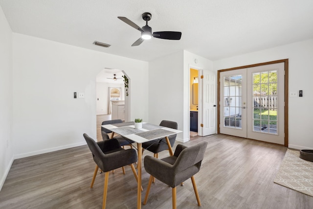 dining area with visible vents, french doors, a ceiling fan, and wood finished floors
