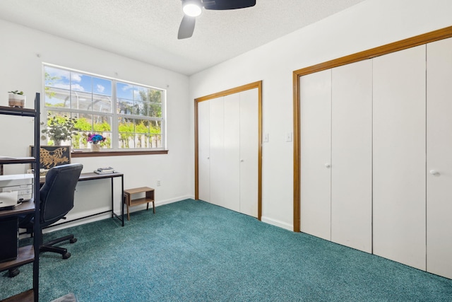 carpeted office with a textured ceiling and ceiling fan